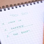 Handwritten to-do list on graph paper notebook with pen. Ideal for organizing tasks.